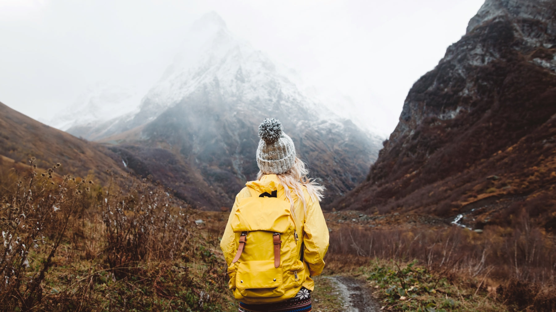 women hiking alone wearing backpack full of camping gear