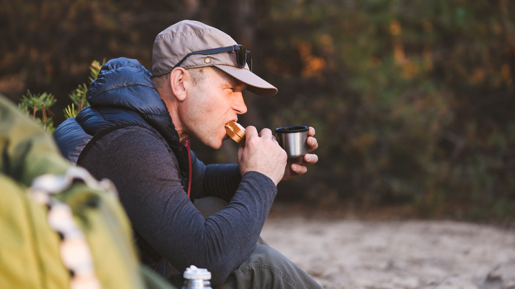 man eating a sandwich while hiking