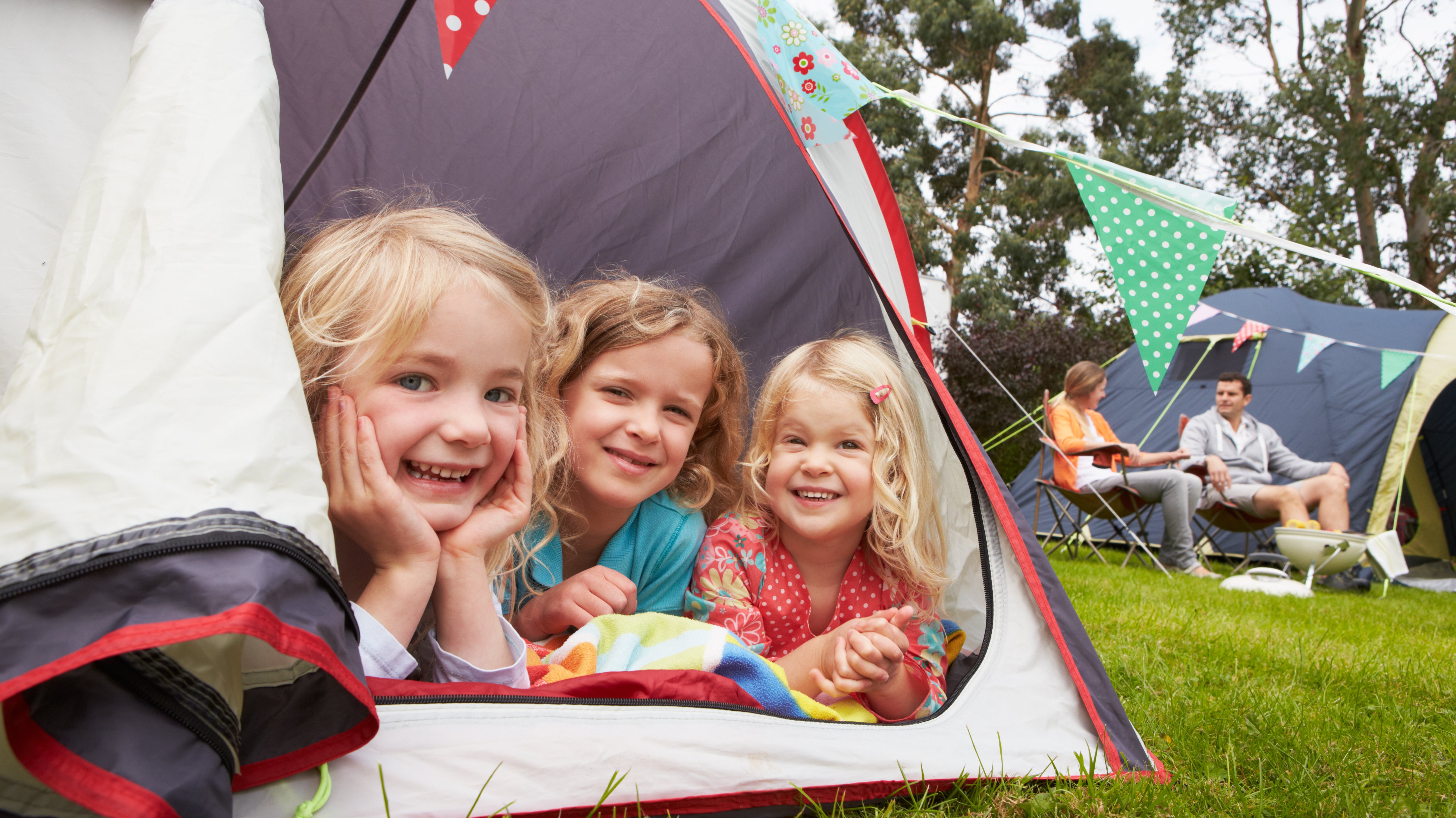three-kids-in-tent-smiling-on-family-camping-trip