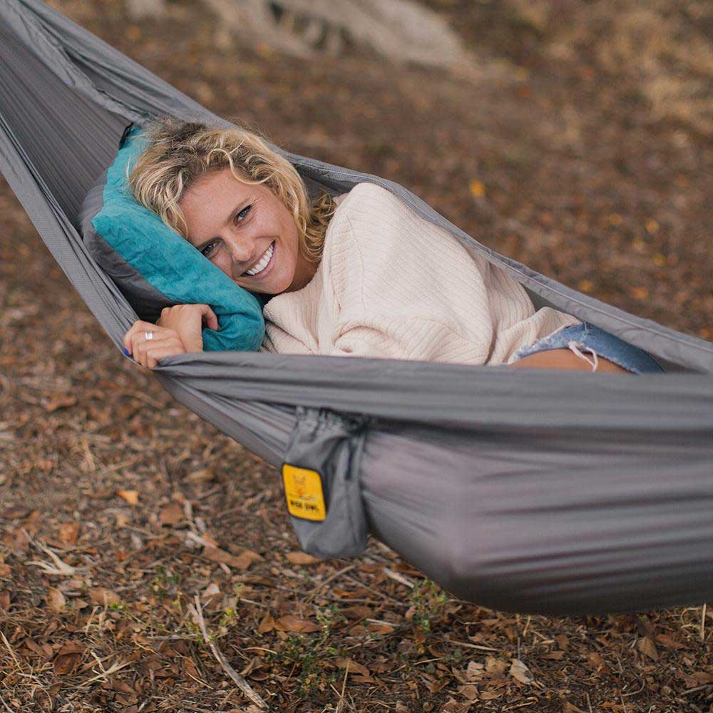 Women laying in a hammock using a camping pillow.