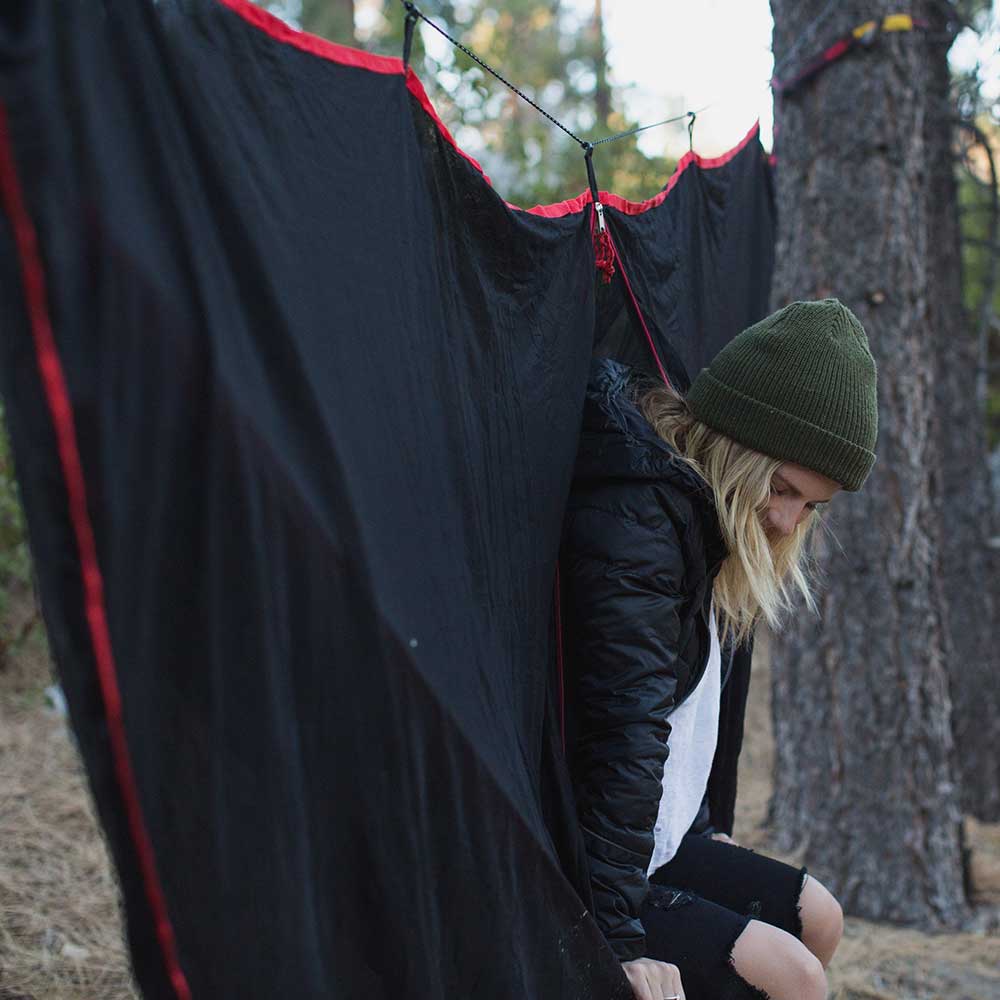 Women in a hammock enjoying nature with a hammock bug net.
