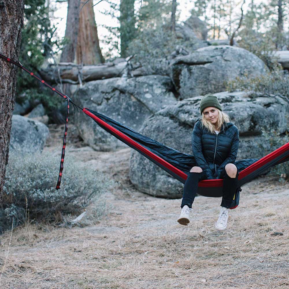 Women smiling while sitting in a hammock using Wise Owl hammock straps.