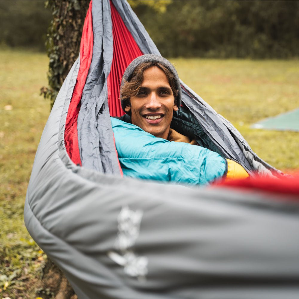 Man using an underquilt outdoors to stay warm.