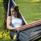 Women relaxing in a portable hammock outside.