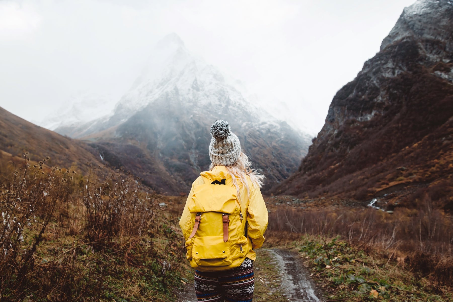 women hiking alone wearing backpack full of camping gear 