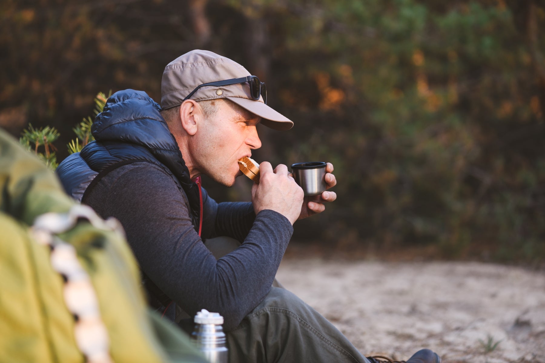 man eating a sandwich while hiking