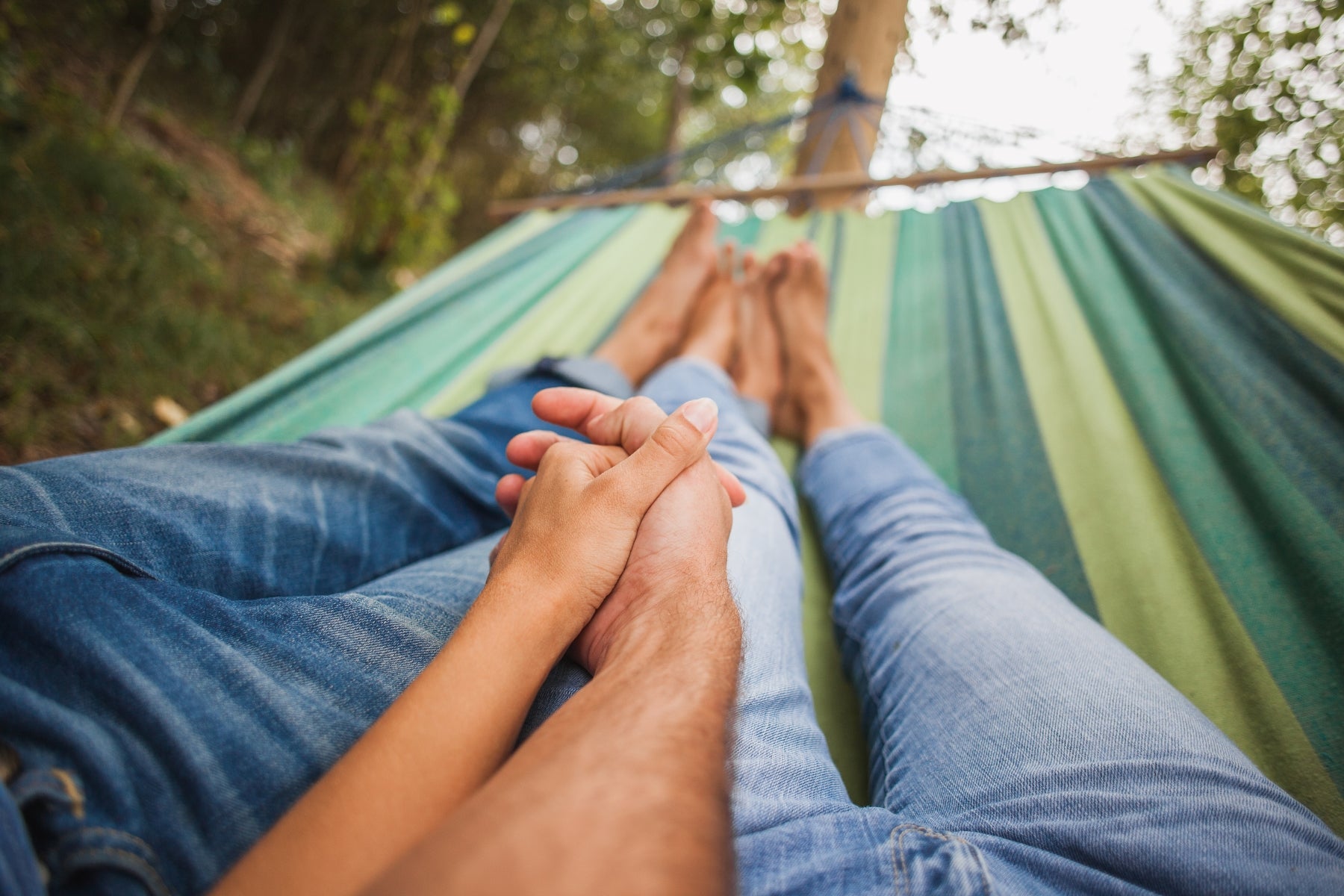 couple on a valentine's date in a hammock holding hands