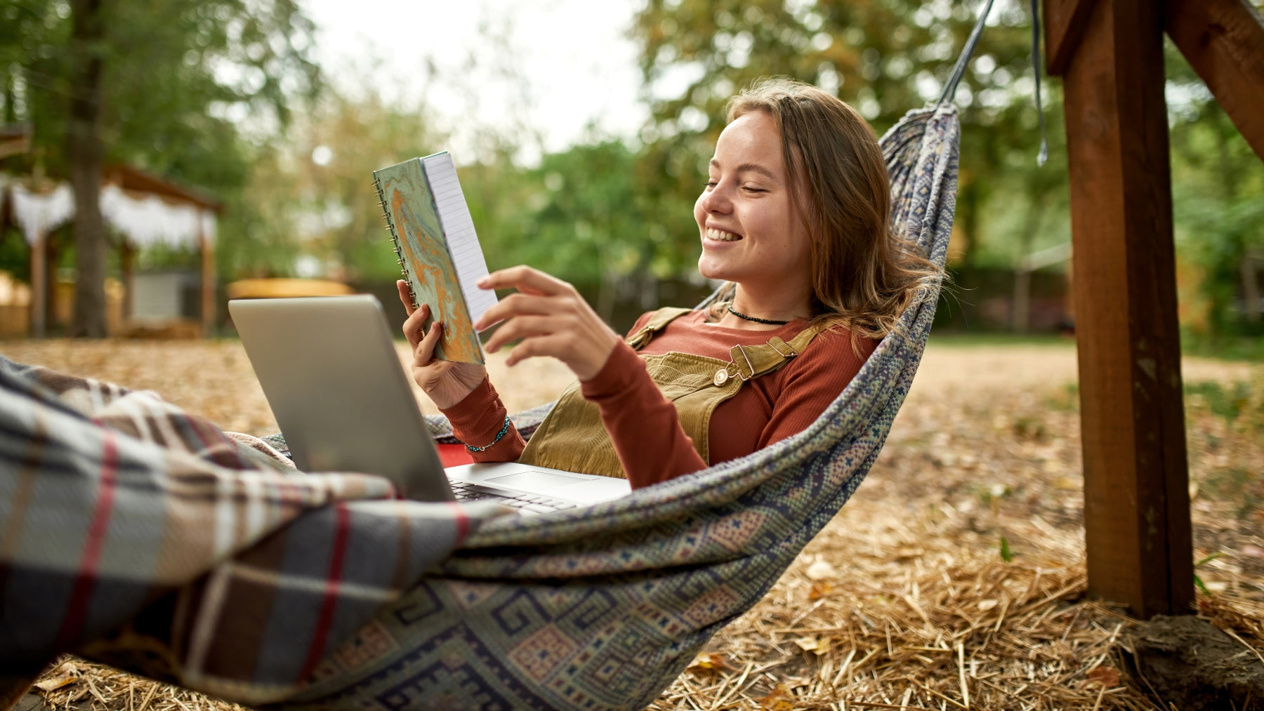 woman in hammock reading a book while looking up types of hammocks on computer