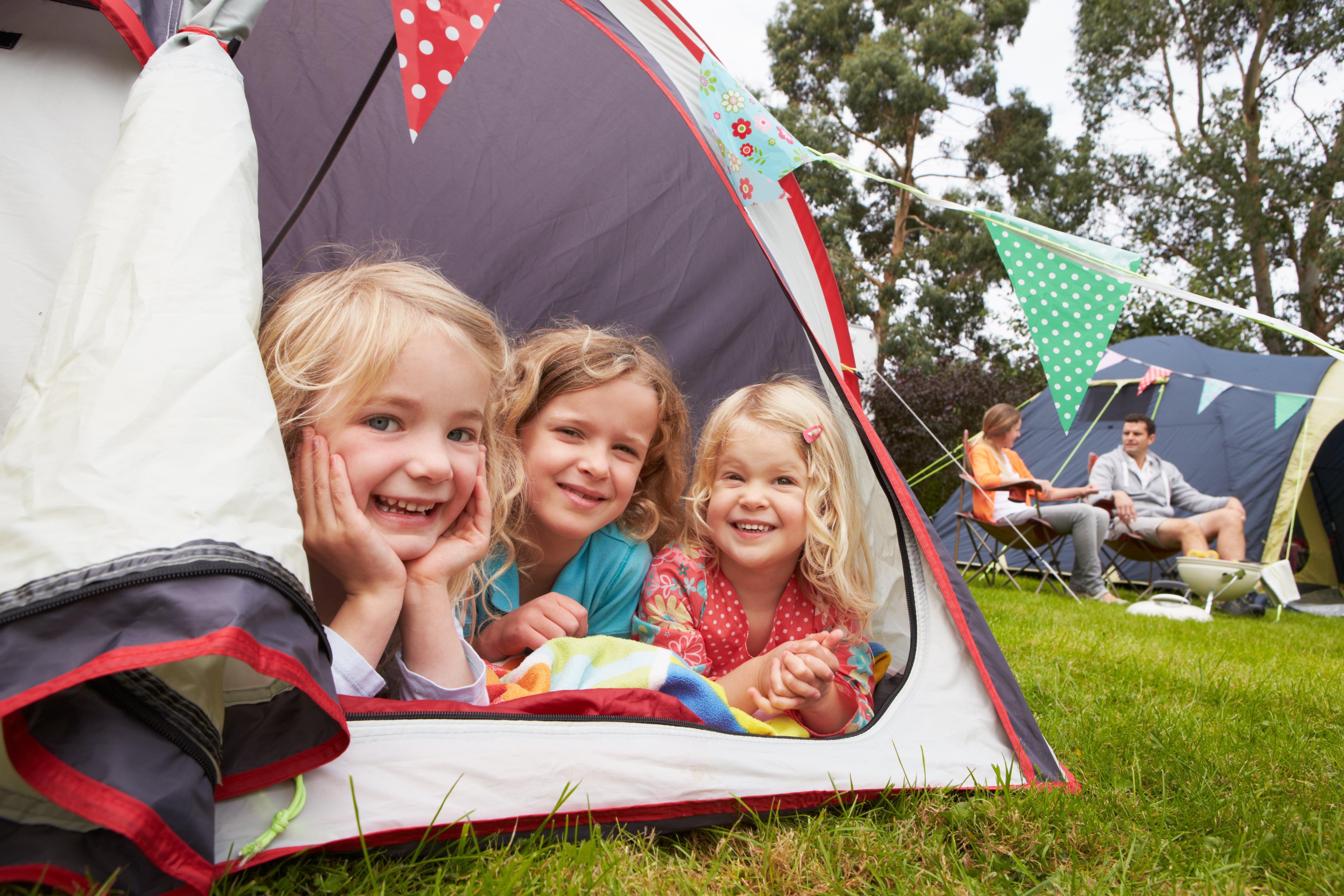 three-kids-in-tent-smiling-on-family-camping-trip