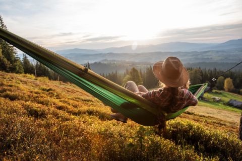 person-relaxing-in-a-hammock-looking-at-the-mountains
