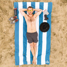 Man laying on a Blue Striped Beach Towel