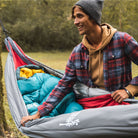 Man opening a hammock underquilt because it is cold outside.