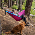 Couple enjoying the outdoors in their two person hammock.